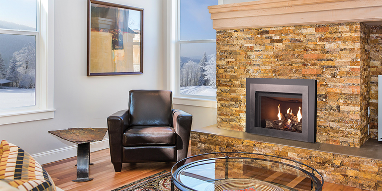 A contemporary living space with a natural stone fireplace, upgraded with a high-efficiency wood burning stove insert
