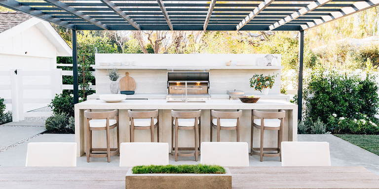 A custom outdoor kitchen layout with a full bar area and seating 